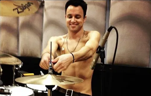Isaac Carpenter acomodando su batería mientras sonríe Isaac Carpenter nuevo baterista de Guns N’ Roses