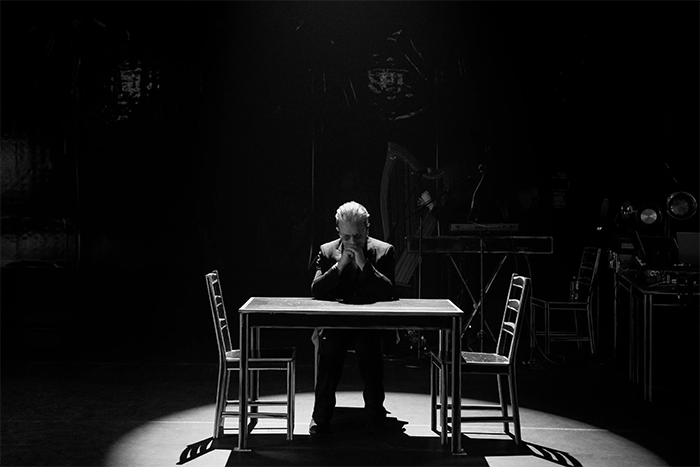 Bono sentado en la silla bajo la luz documental de Bono