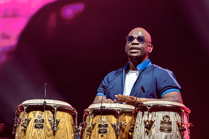 Percusionista de la banda 4.40 tocando los bongos durante el concierto juan luis guerra concierto madrid 2025