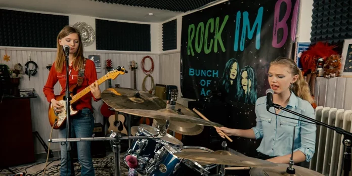 Las hermanas de Bunch of Ace tocando guitarra y batería durante un ensayo en su estudio