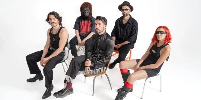 El dúo ELYELLA junto a los músicos sentados en una sesión de fotos con estética minimalista