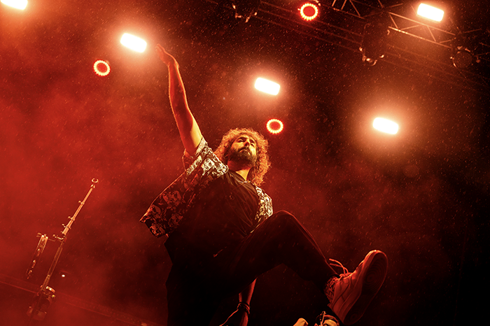 Mikel Izal levantando el brazo entre luces rojas y ambiente intenso en su concierto Galicia Fest arranca en Vigo con un desfile de himnos y emociones
