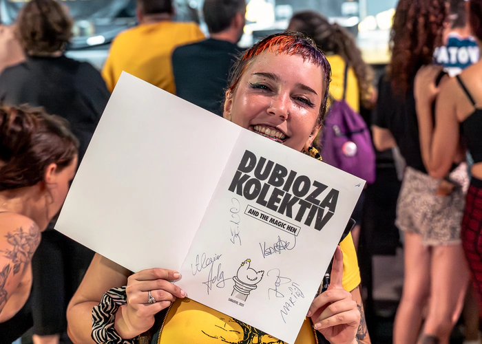 Chica del público con un cartel firmado por la banda Dubioza Kolektiv en Madrid
