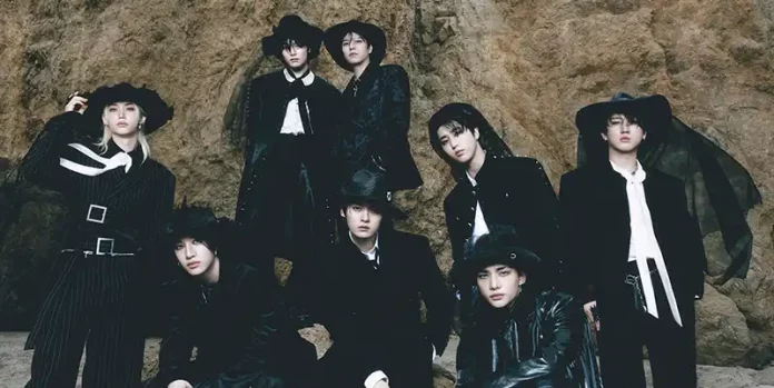 Grupo de músicos posando con estética oscura y vestuario inspirado en estilo western sobre fondo rocoso