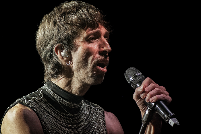 Artista masculino cantando en primer plano con iluminación de concierto Daniela Spalla y Esteman en Madrid